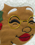 Close-up of Nana Klaus with gold glasses and white hair on the Noire Noel stocking.