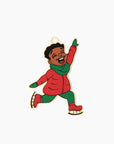 an ornament front featuring  a young black boy smiling and wearing a red coat , green scarf, and ice skates