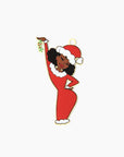 an ornament front featuring  a black women in a red dress and Santa hat holding a mistletoe in the air