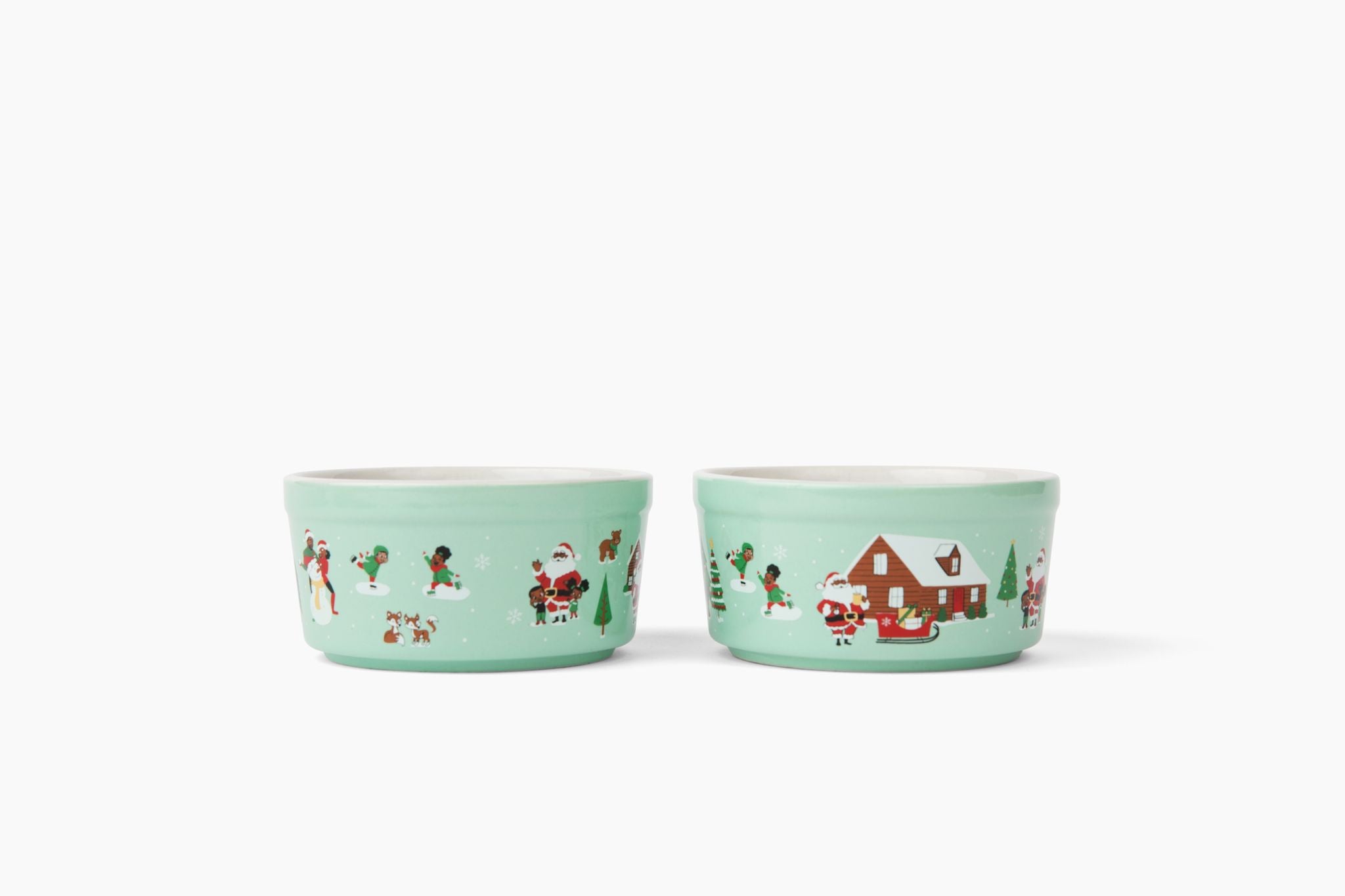 2 teal ceramic ramekins with black characters in Christmas and holiday snow scenes