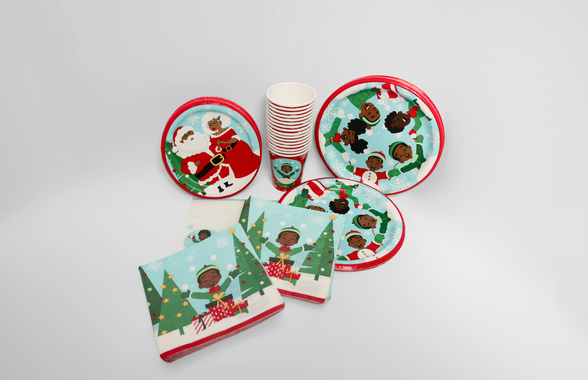 Christmas-themed paper plates and napkins with festive designs on a white background