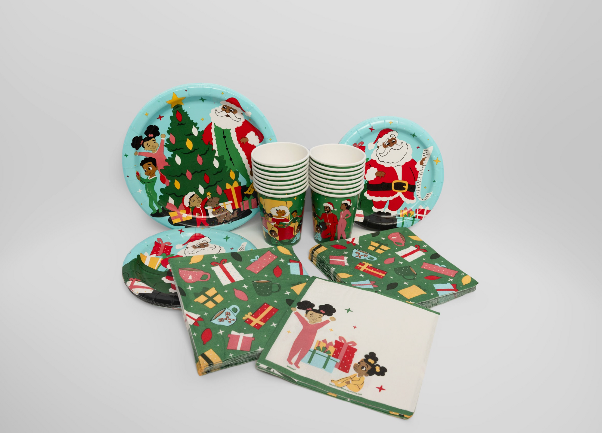 Christmas-themed paper plates, cups, and napkins on a white background