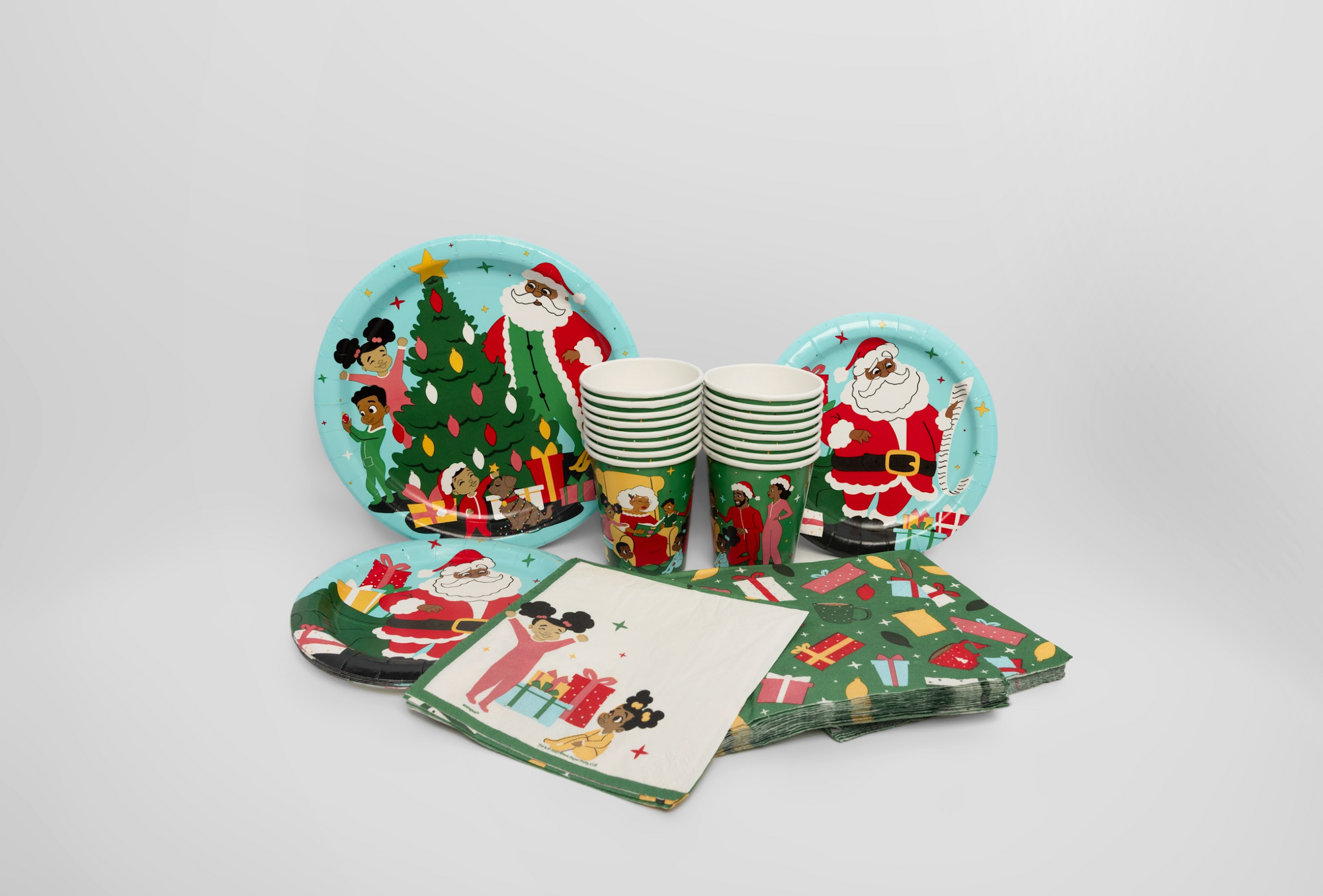 Christmas-themed paper plates, cups, and napkins on a white background