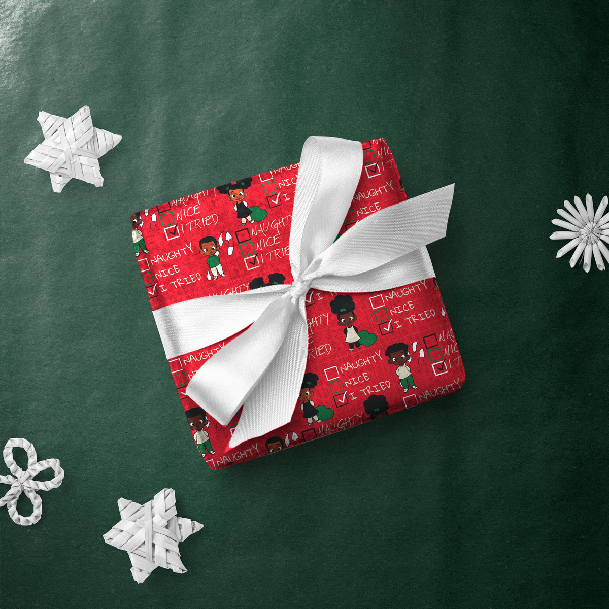 Gift box wrapped in Naughty Nice I Tried gift wrap with a white ribbon