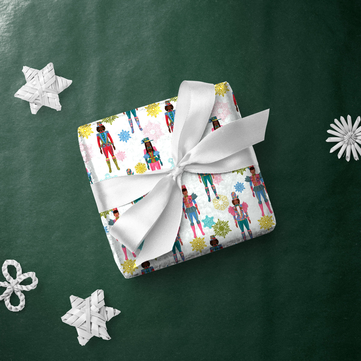 Gift box wrapped in Nutcracker Queens gift wrap with a white ribbon
