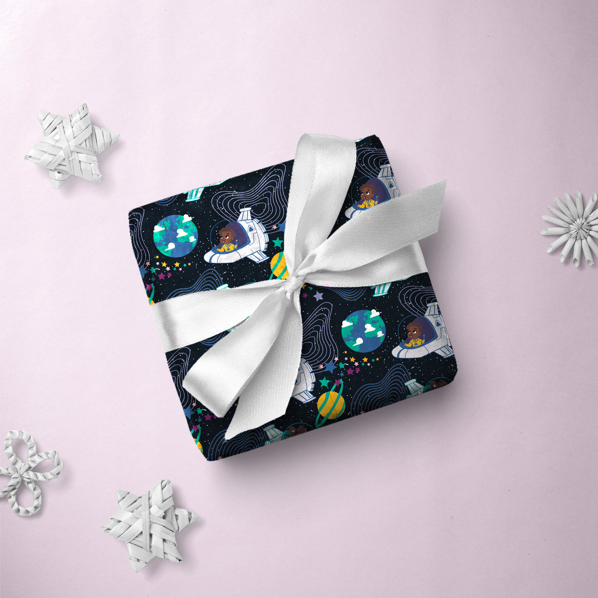 Gift box wrapped in Kids in Spaceships gift wrap with a white ribbon