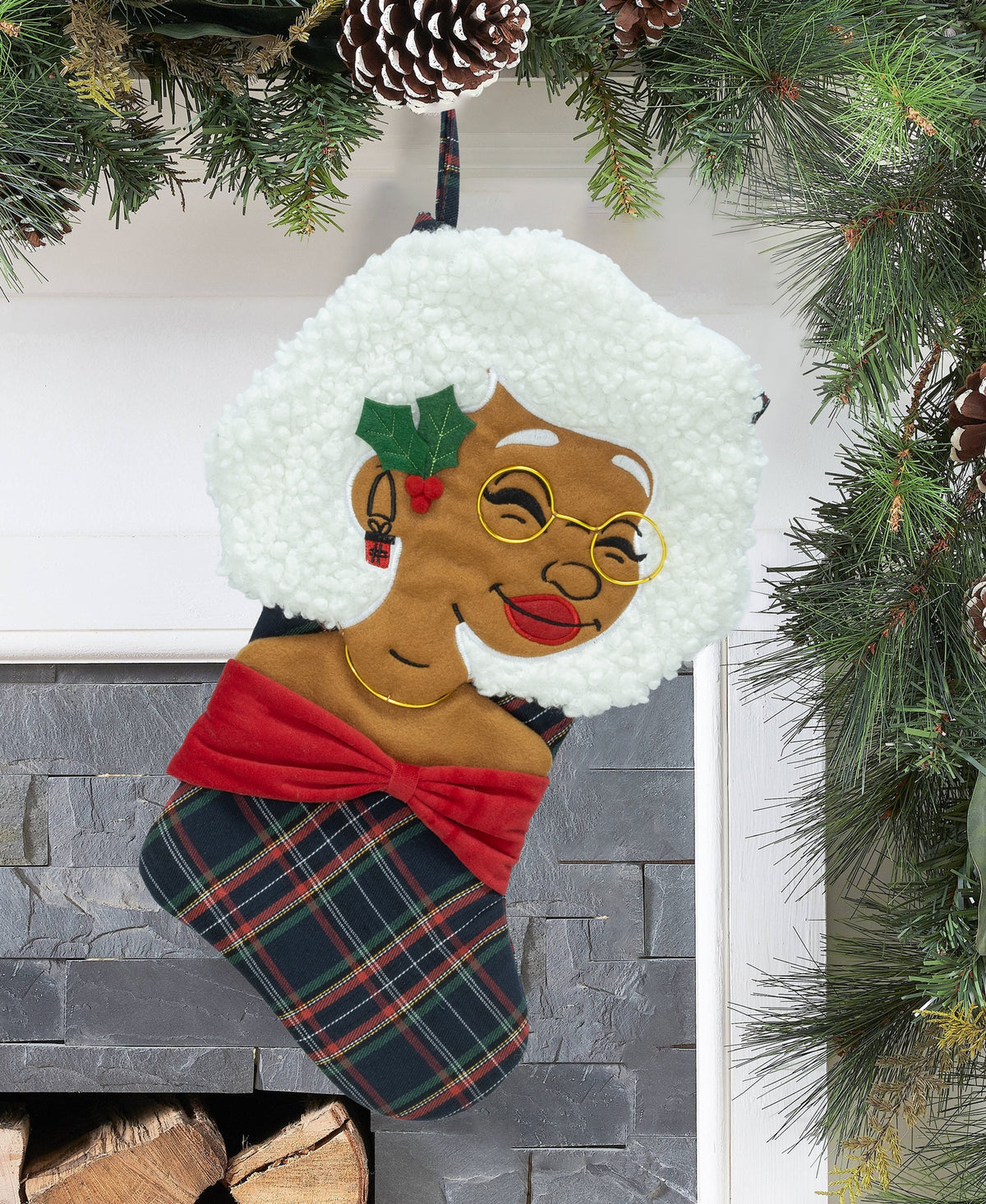 Nana Klaus Noire Noel plaid holiday stocking hanging by a fireplace.