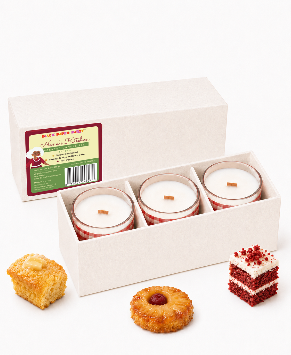 Nana’s Kitchen candles in an open gift box beside cake and cornbread fragrance props.