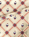 Noire Noel gift wrap with a cream plaid pattern and illustrated Black Santa faces.