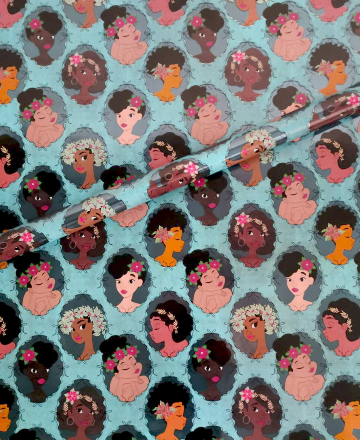 Noire Noel gift wrap with illustrated Black portraits on a blue background.