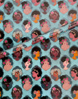 Noire Noel gift wrap with illustrated Black portraits on a blue background.