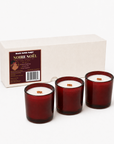 Black Paper Party Noire Noel three-candle gift set with burgundy glass vessels, wood wicks and a blush gift box.