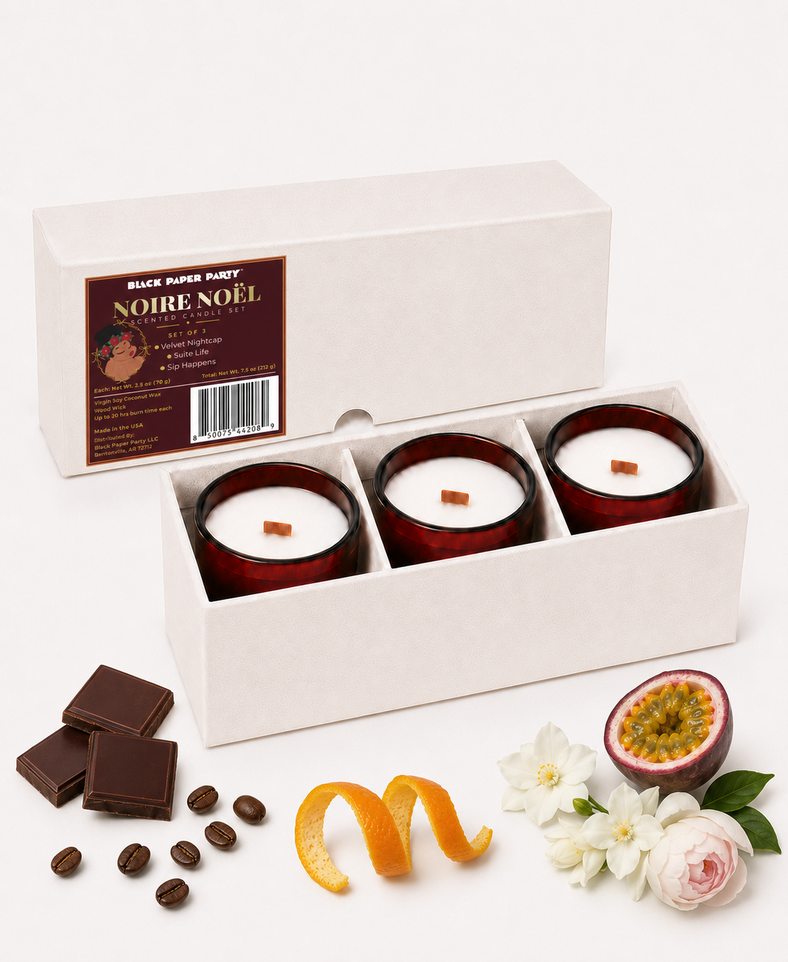Noire Noel candle gift set in an open box with chocolate, fruit and coffee fragrance props.